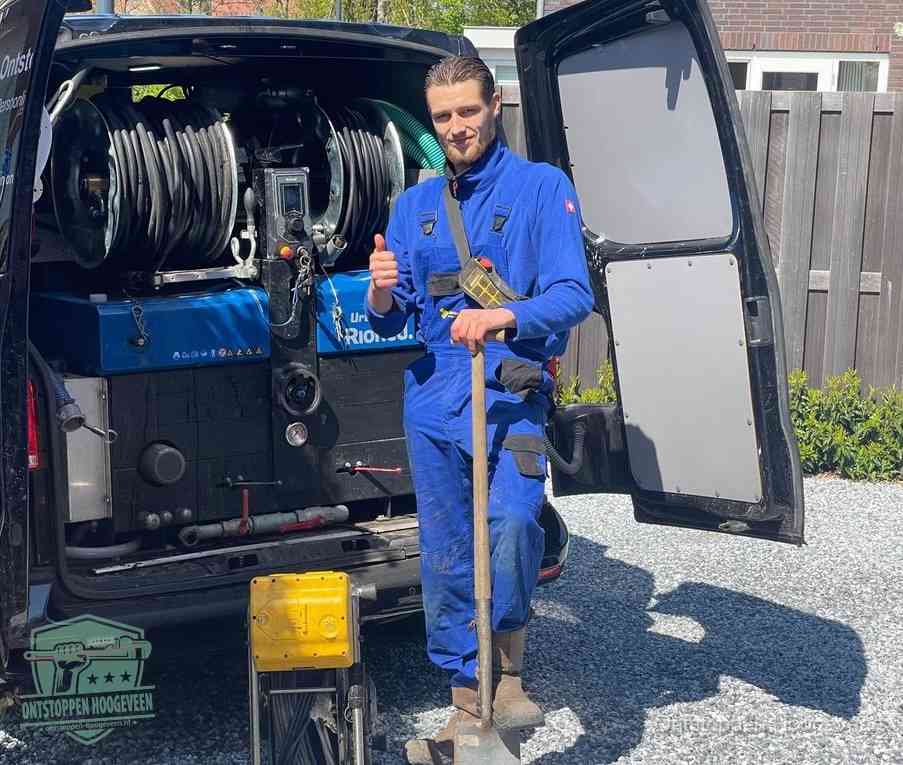 Een tevreden monteur met opgestoken duim naast de bestelbus, slim ingrijpen bespaart kosten bij een verstopte afvoer in Hoogeveen
