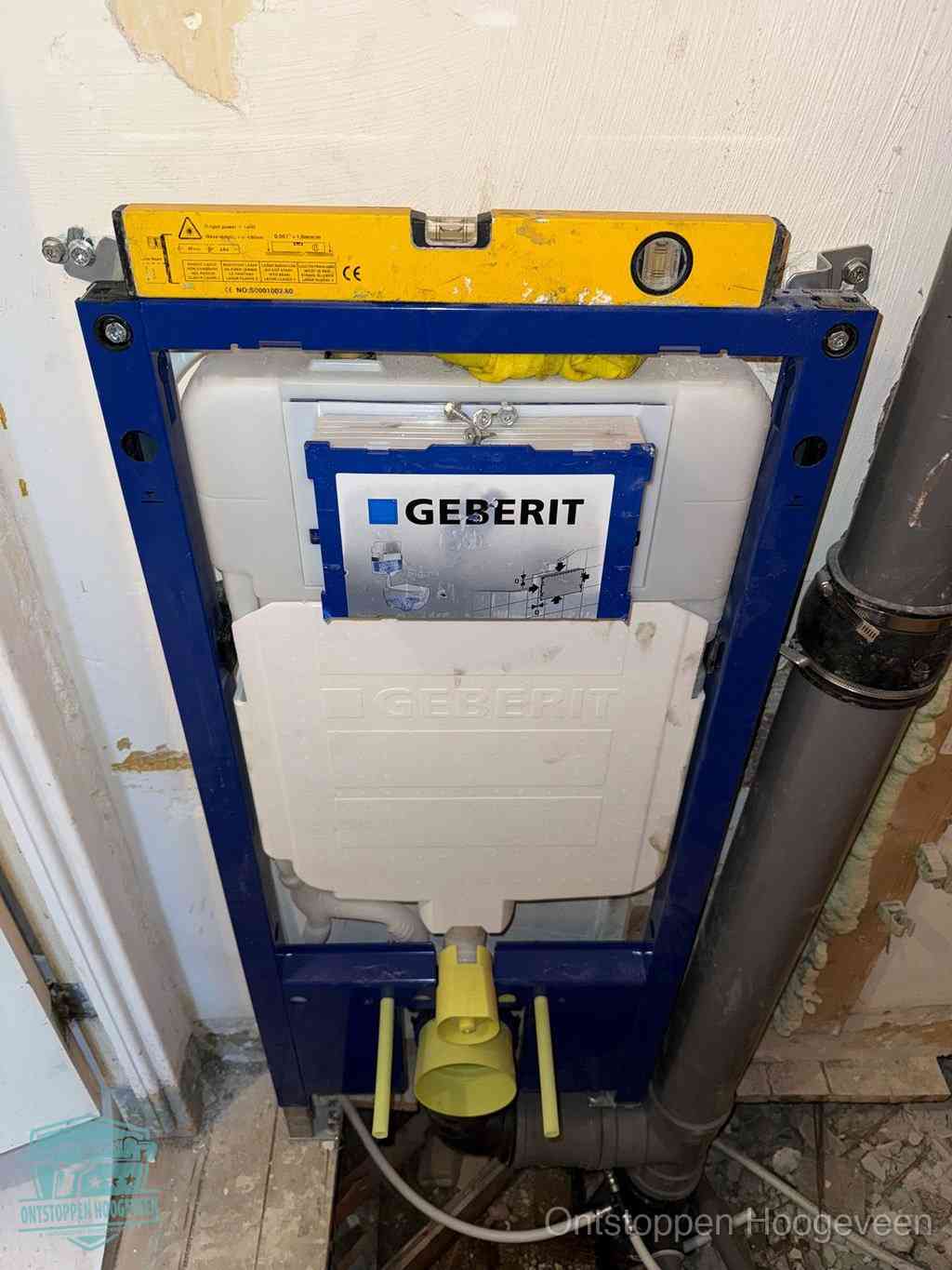Een Geberit inbouwreservoir met frame voor een hangtoilet tegen de wand, met de afvoerbocht naar de vloer, kenmerkend voor een verstopt hangtoilet in Hoogeveen