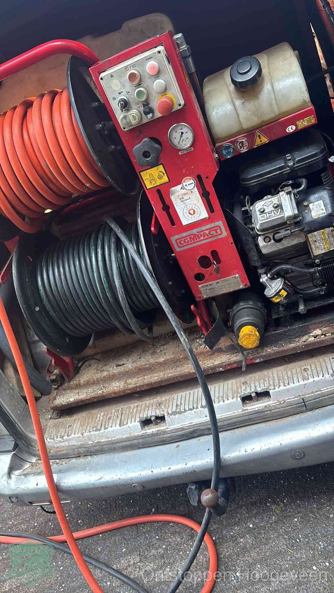 Een rood hogedruk-rioolreinigingstoestel in de laadbak van de bedrijfsbus, apparatuur voor een hardnekkige afvoerverstopping in Hoogeveen