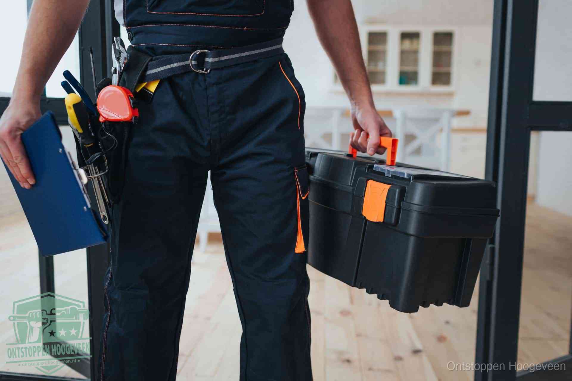 Een monteur met gereedschapsriem en klembord, klaar om een transparante prijs voor het afvoer ontstoppen in Hoogeveen te geven
