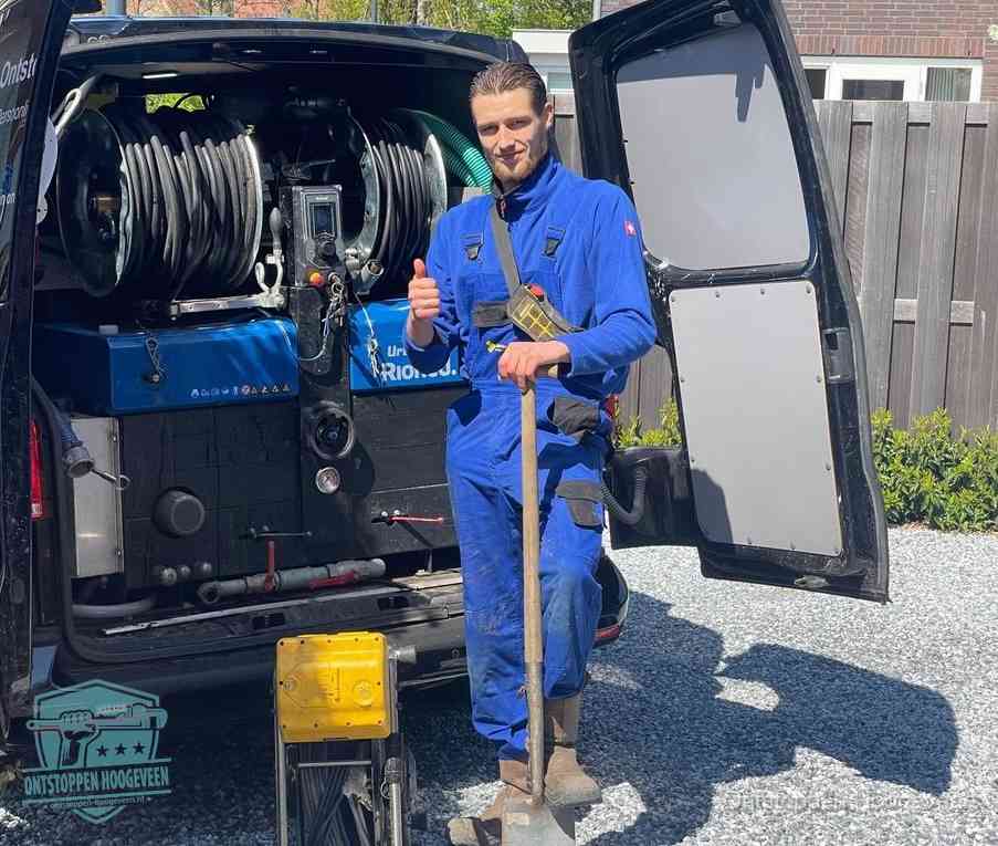 Monteur met duim omhoog bij de rioolreinigingsbus, duidelijke kosten voor riool ontstoppen in Hoogeveen