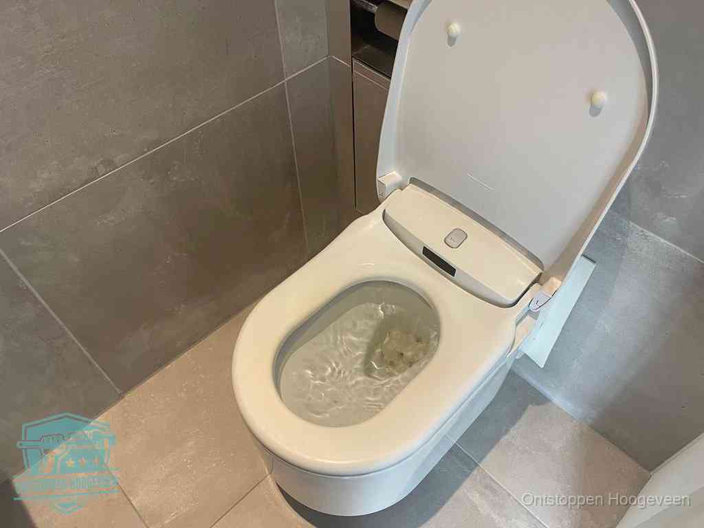 Een toiletpot vol troebel water met drijvend papier en restanten, de meest voorkomende oorzaak van een verstopte wc in Hoogeveen