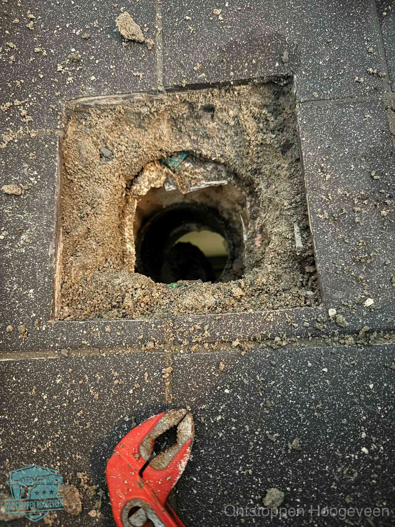 Geopend rioolputje op de erfgrens dat laat zien wie eigenaar is van de riolering in Hoogeveen