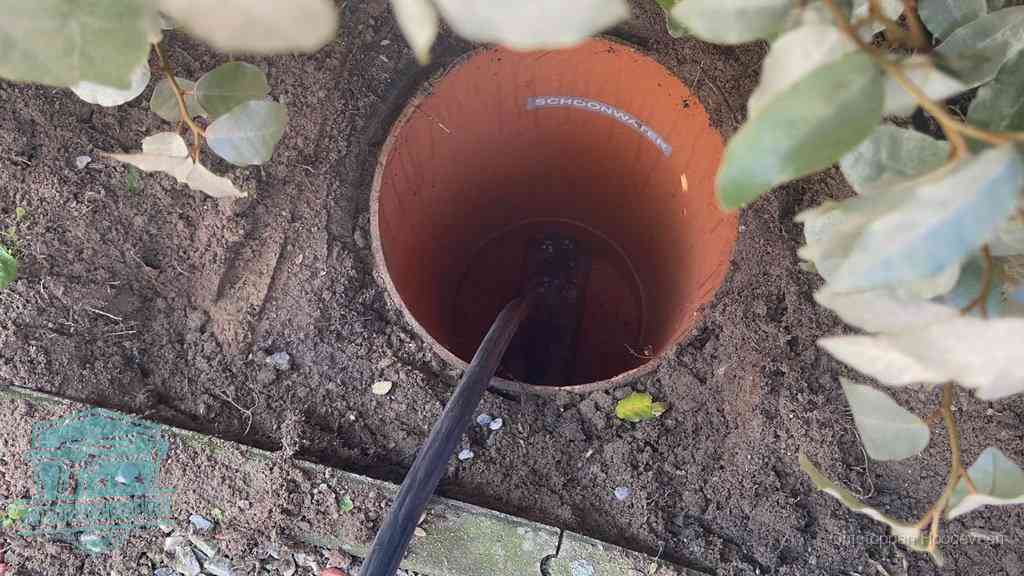 Open inspectieput in de tuin waar een veer rioolvliegjes en stankoverlast aanpakt in Hoogeveen
