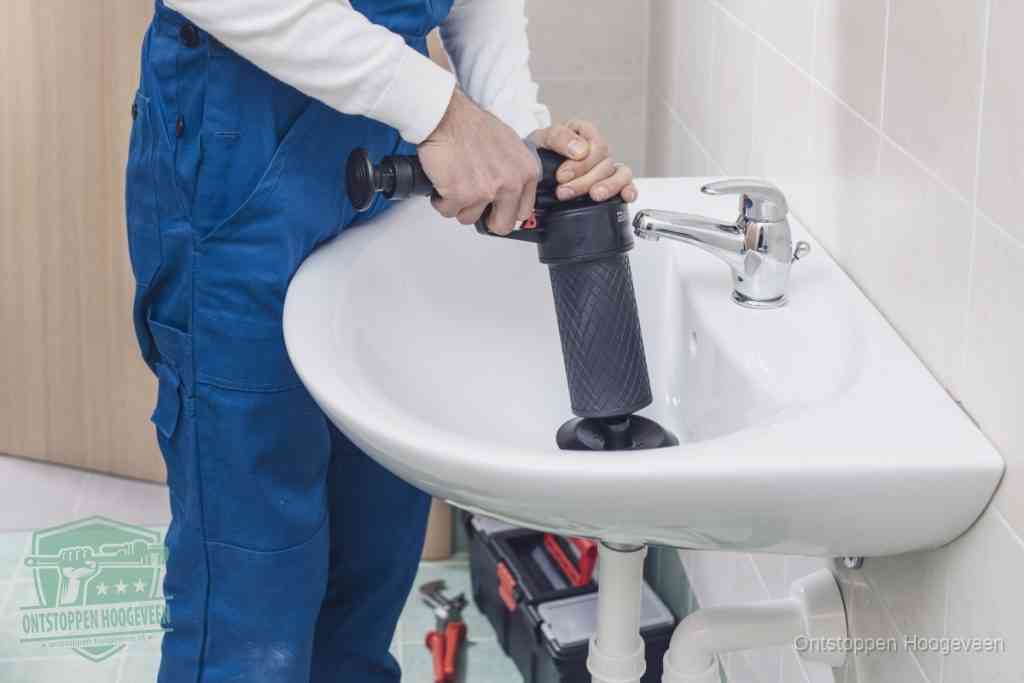 Een te ruwe doe-het-zelf poging met een hand-pomp op de afvoer van een badkamer-wastafel, een van de veelgemaakte fouten bij afvoer ontstoppen in Hoogeveen
