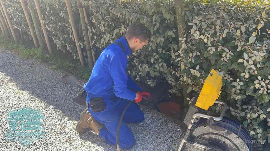 Monteur aan het werk bij een rioolput, de werkwijze voor riool ontstoppen in Hoogeveen