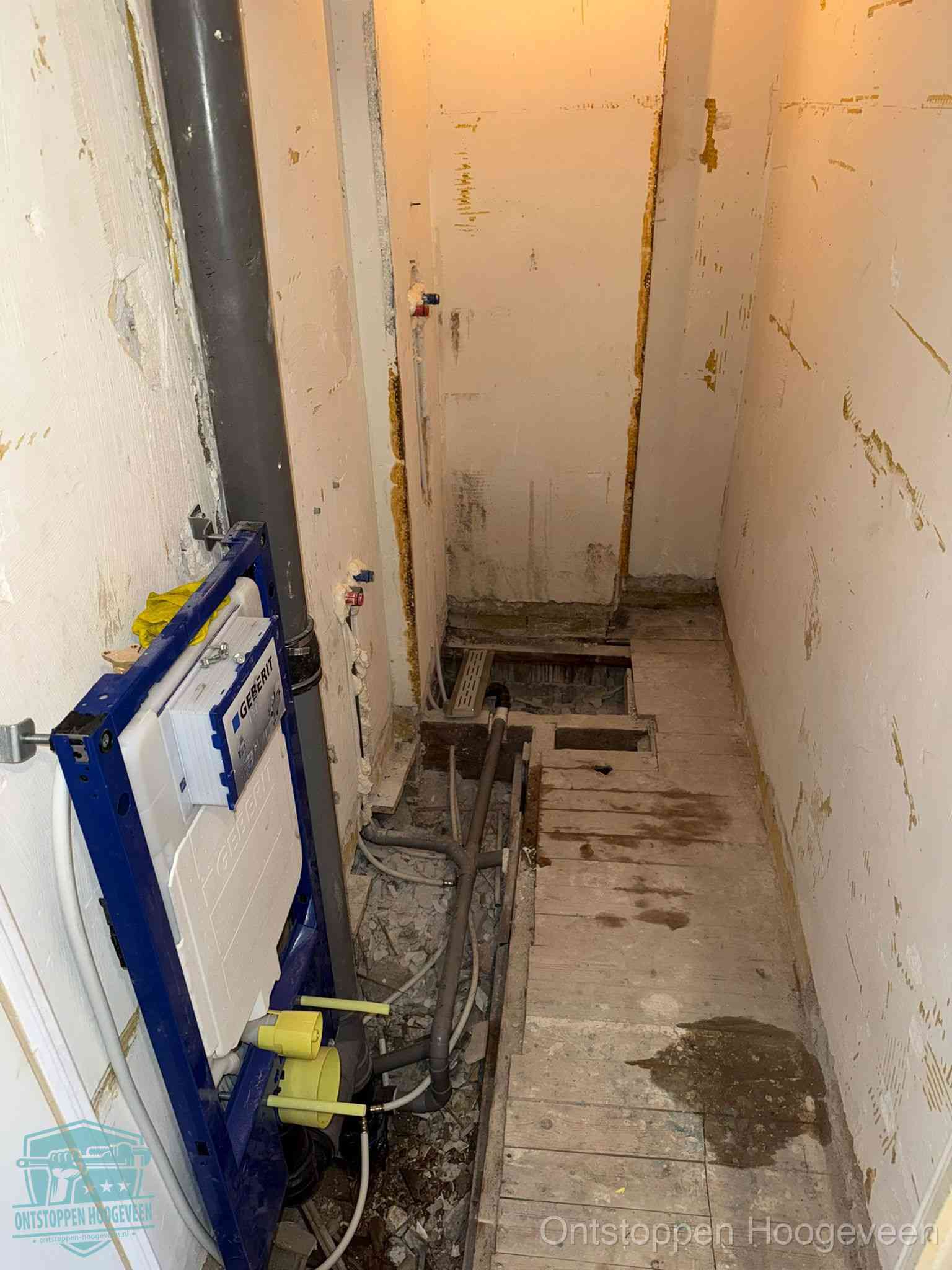 Een opgebroken toiletruimte tijdens renovatie met een Geberit inbouwreservoir en blootliggende oude afvoerleidingen, typisch voor oudere woningen in Hoogeveen